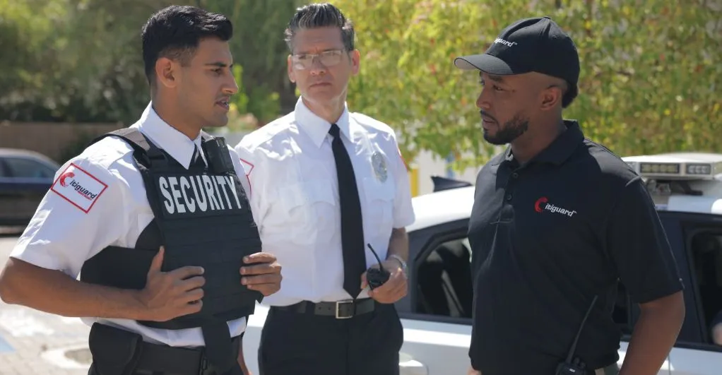 (Three security professionals from Citiguard engage in a tactical discussion near a patrol vehicle, demonstrating coordination and readiness in field operations.)