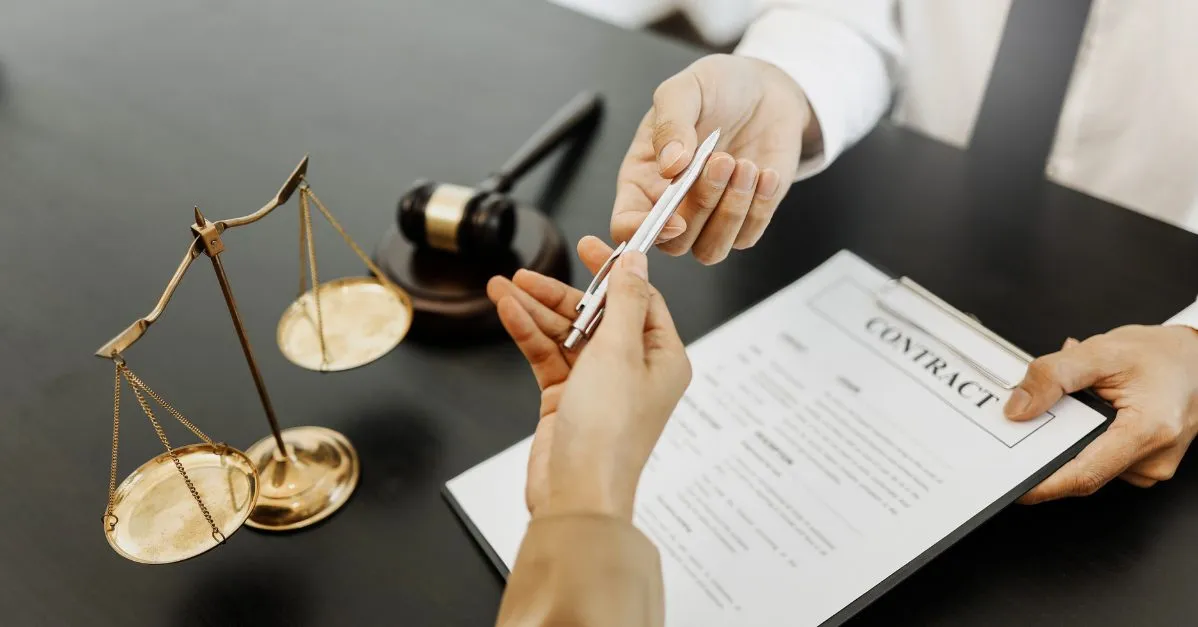 (person grabbing a pen to sign a contract)